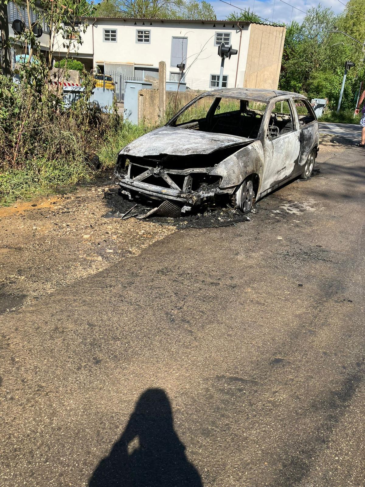 El coche calcinado junto al paso a nivel de El Bayu en Pola de Siero.