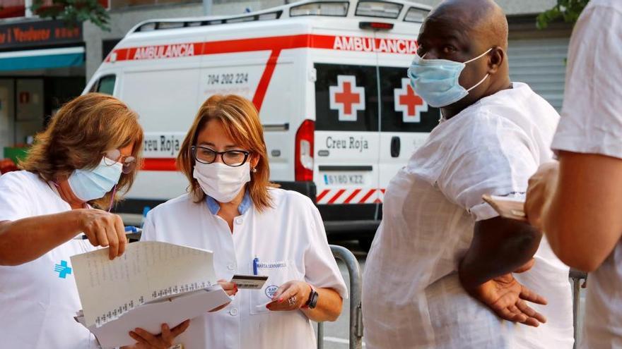 Profesionales sanitarios informan a unos vecinos del barrio del Remei de Vic.