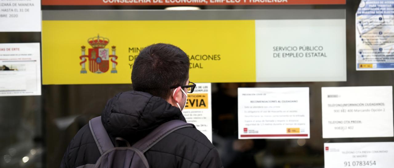 Un¡ joven ante una oficina de empleo