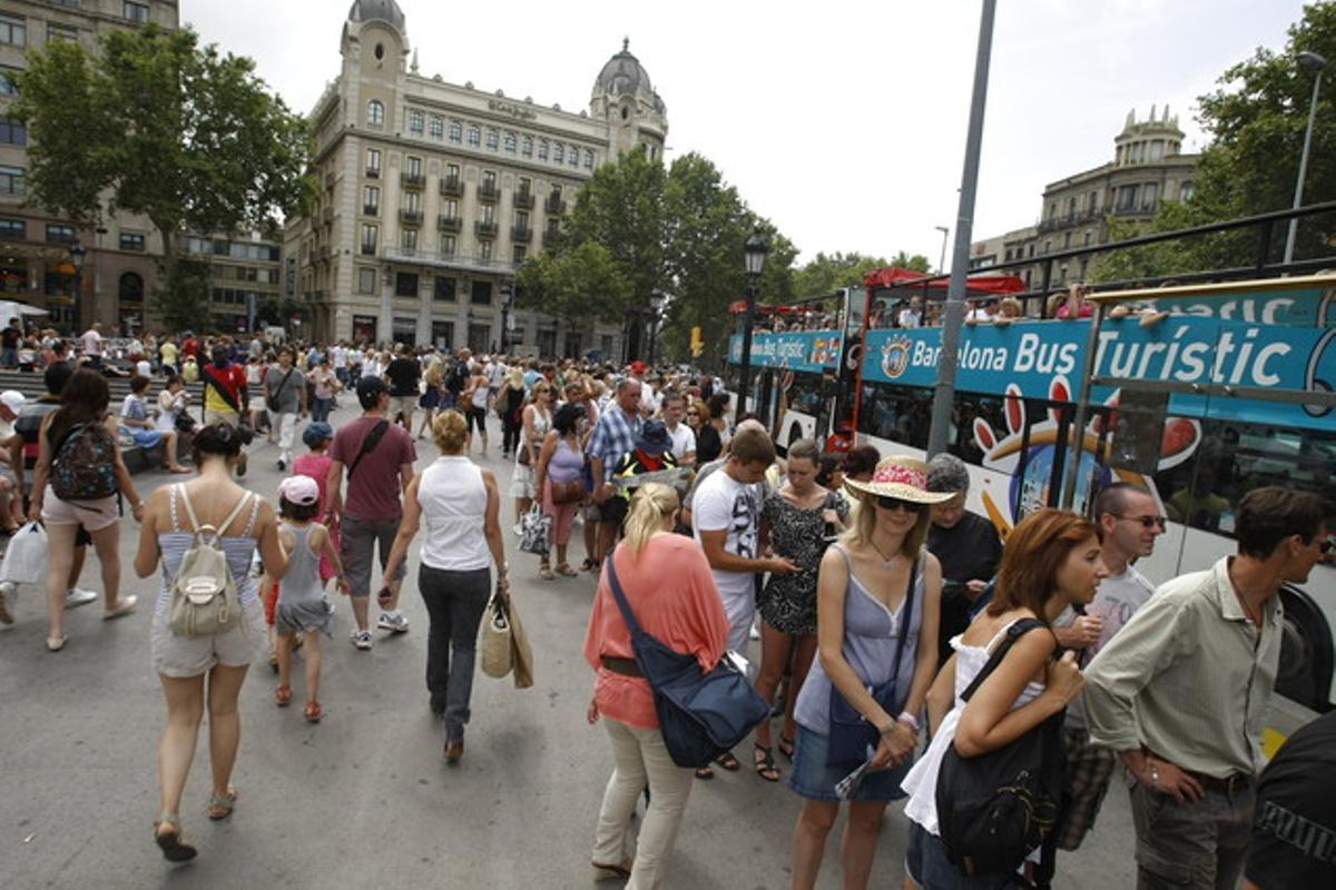 Grans cues de visitants per agafar el Bus Turístic a plaça Catalunya.