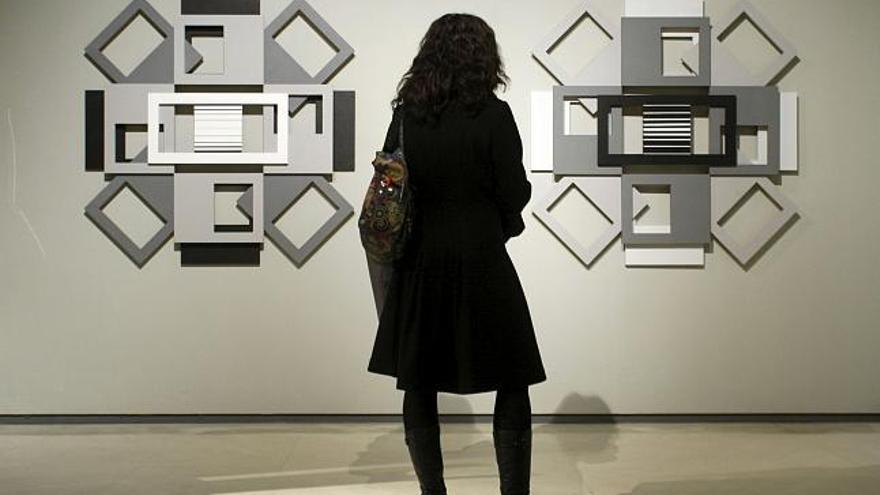 Una mujer observa la instalación 4 relieves (2006), de Carmen Zulueta