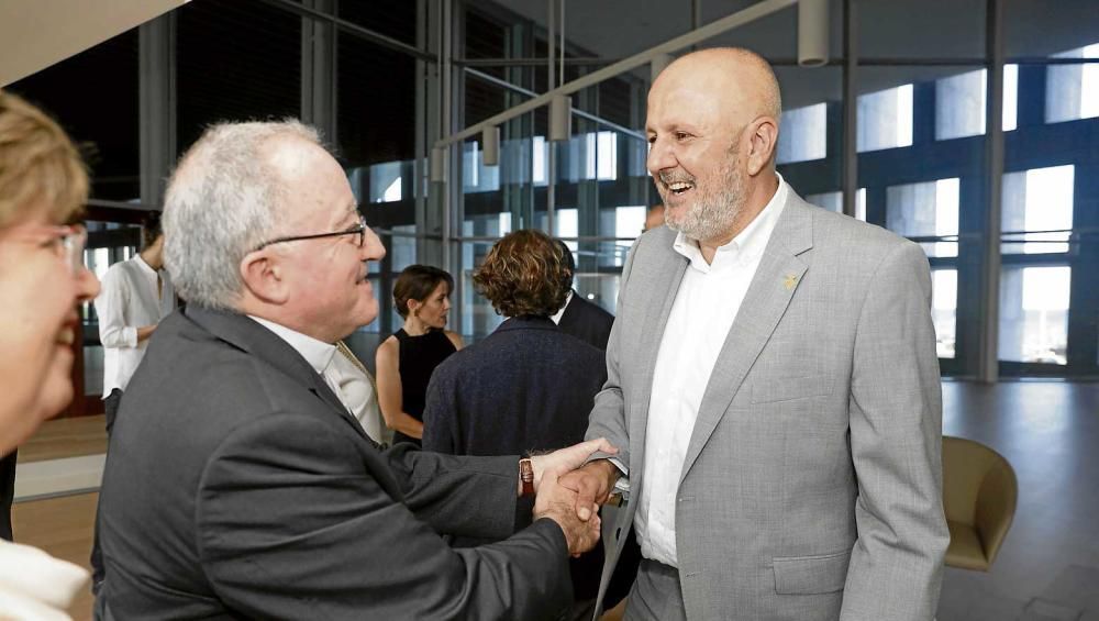 Magdalena Riutort, directora de Cáritas Mallorca, observa a Antoni Vera, vicario general del Obispado de Mallorca, saludando a Miquel Ensenyat, presidente del Consell de Mallorca.