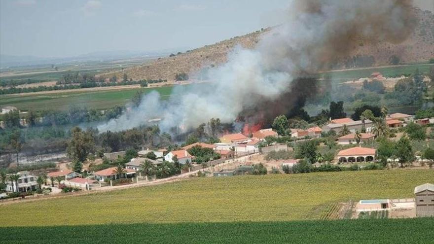 Un incendio, cercano a viviendas, daña vegetación junto al Guadiana