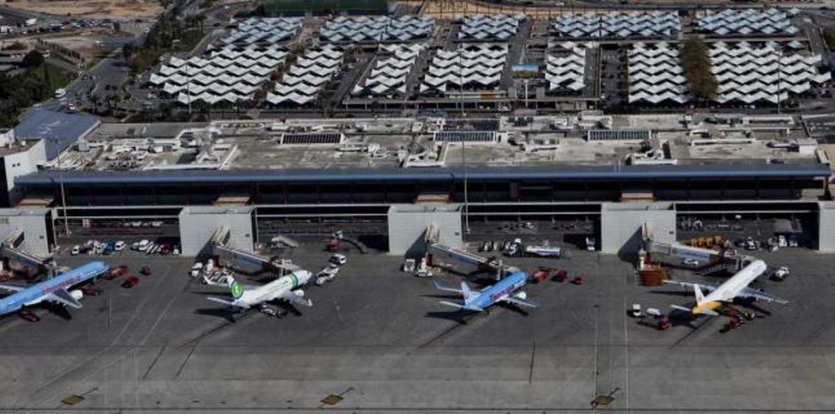 Vista aérea de la antigua terminal de El Altet, cerrada desde abril de 2011 y que Aena ha descartado para su uso aéreo. Detrás, el aparcamiento que aprovecharía Eurovillage.