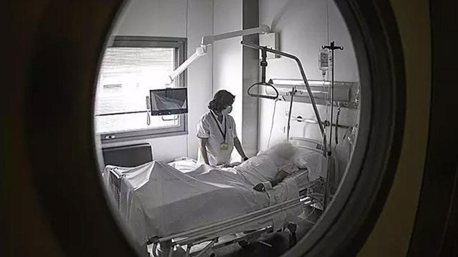 Una enfermera atiende a un paciente en un hospital.