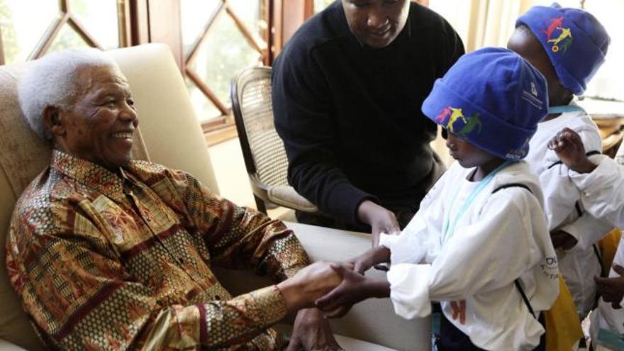 Nelson Mandela recibiendo la visita de niños vecinos de la aldea de Mvezo, donde nació.