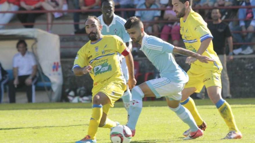 Un jugador del Celta B intenta llevarse un balón entre dos rivales en un lance del partido de ayer en Barreiro. // José Lores