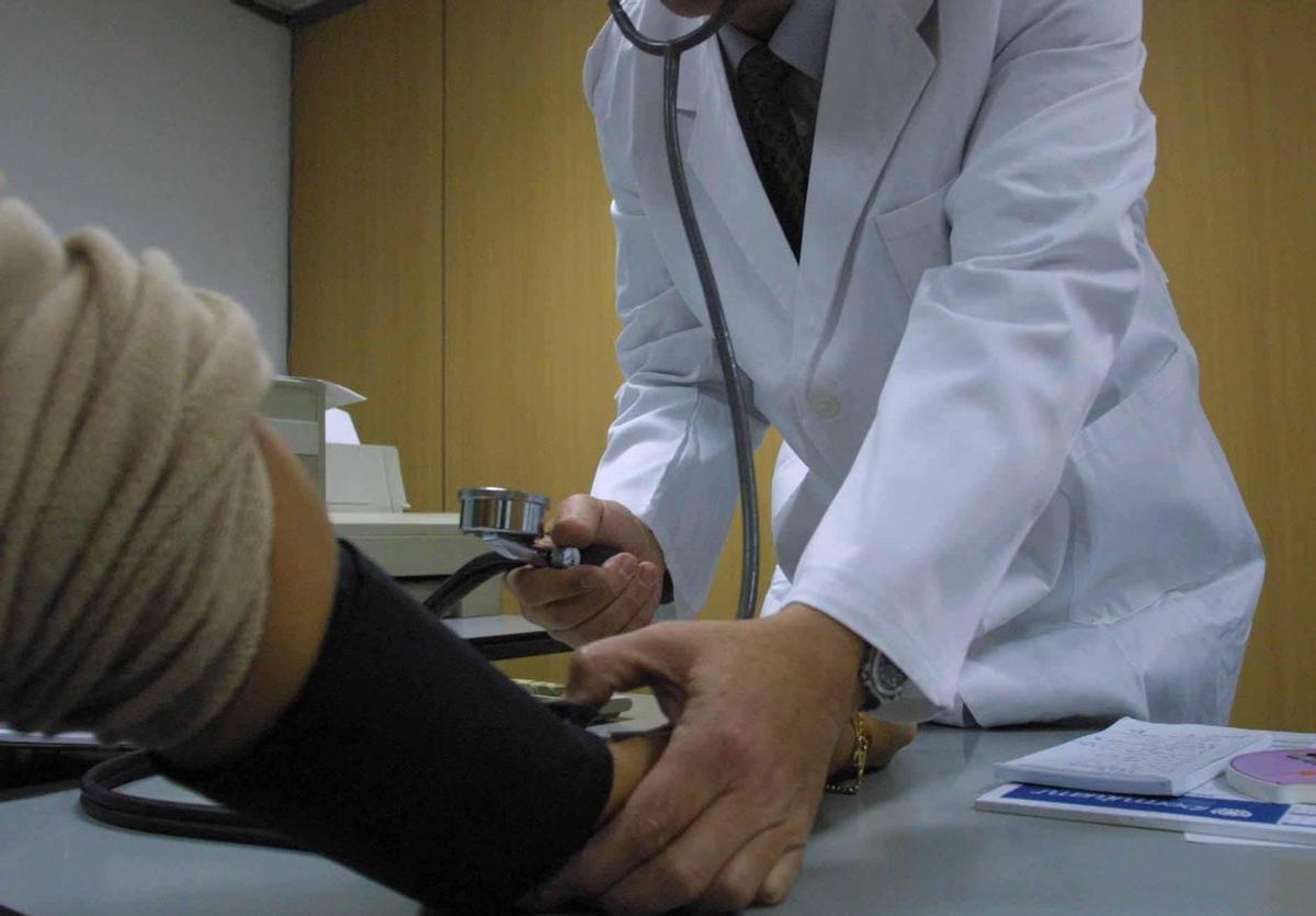 Un médico mide la tensión a un paciente. | A. I. |