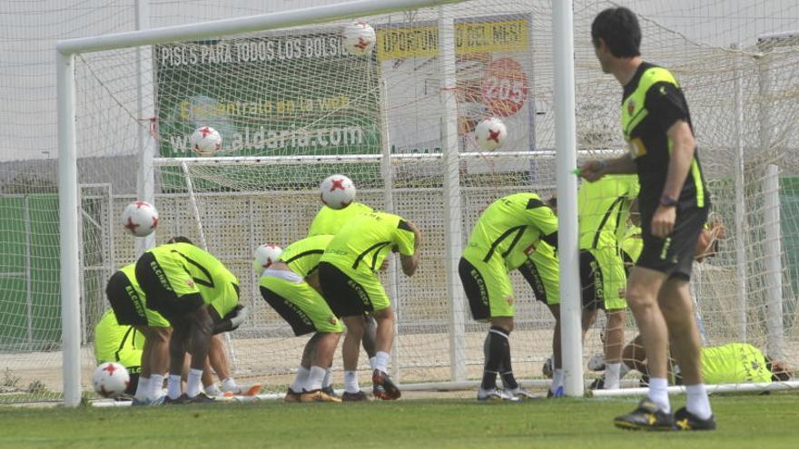 Un grupo de jugadores del Elche debajo de la portería recibiendo balonazos