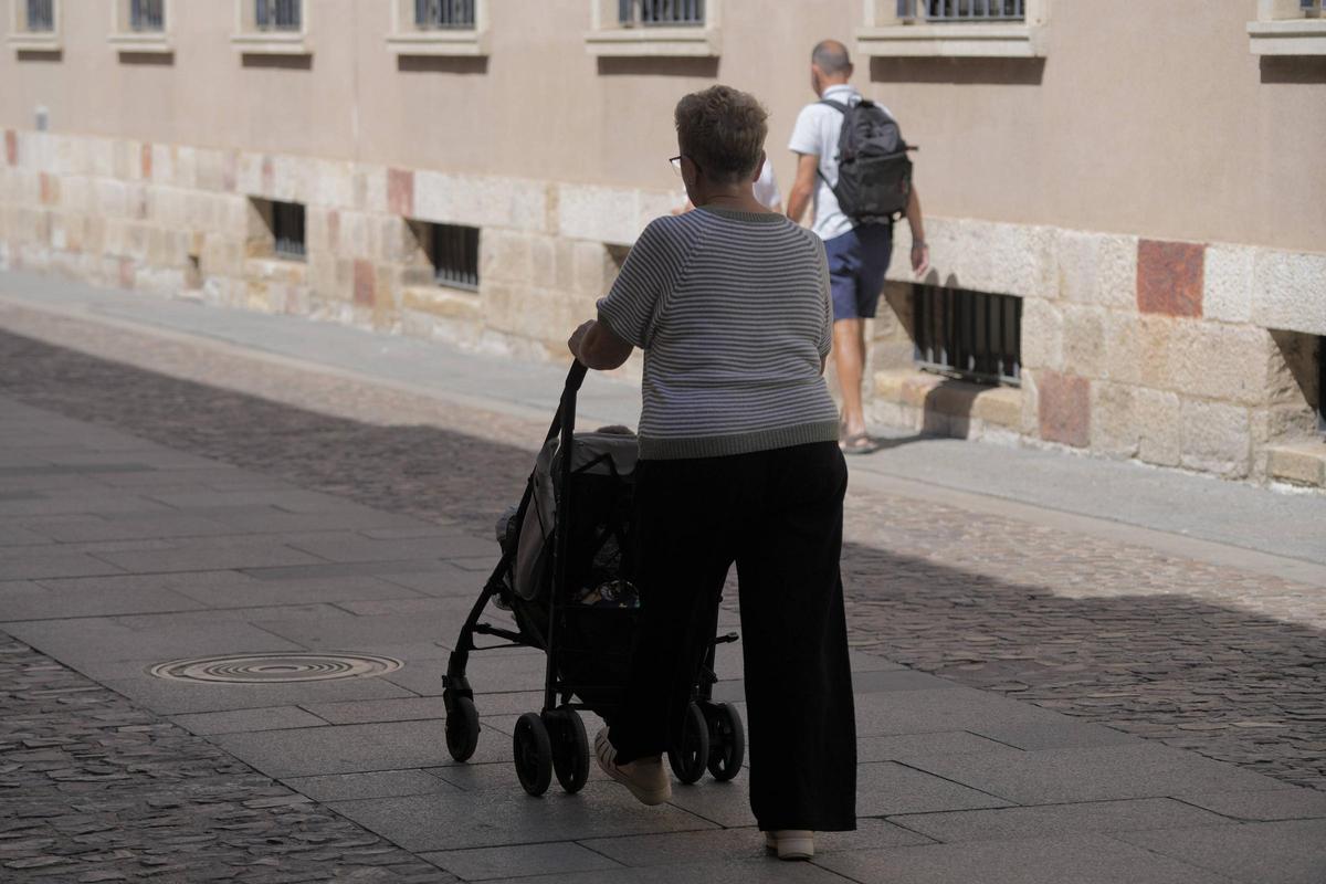 Una abuela pasea a su nieto por el casco antiguo.
