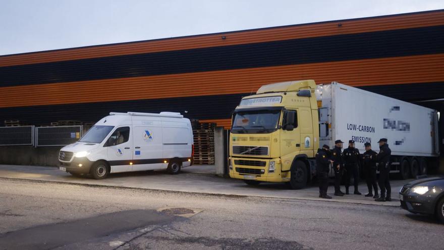 Policías nacionales y un vehículo de la Agencia Tributaria, ante la nave de Cambre. | // KIKO DELGADO/EFE