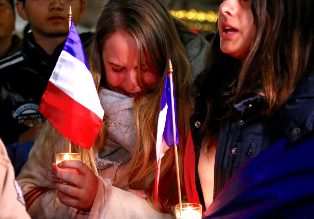 Miembros de la comunidad francesa de Australia lloran mientras suena el himno francés durante el homenaje a las victimas del atentado en Niza.