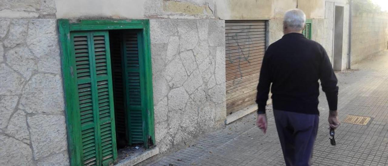 Un transeúnte pasa ante la ventana violentada de una casa usada para el botellón.