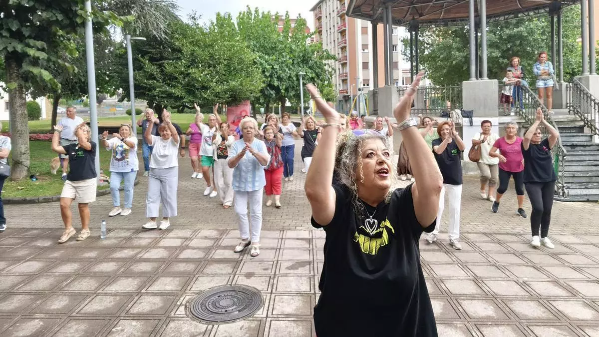 Bailoterapia bajo la lluvia y contra la soledad no deseada en la Pola: "Salimos de casa y hacemos amistades, es una maravilla"