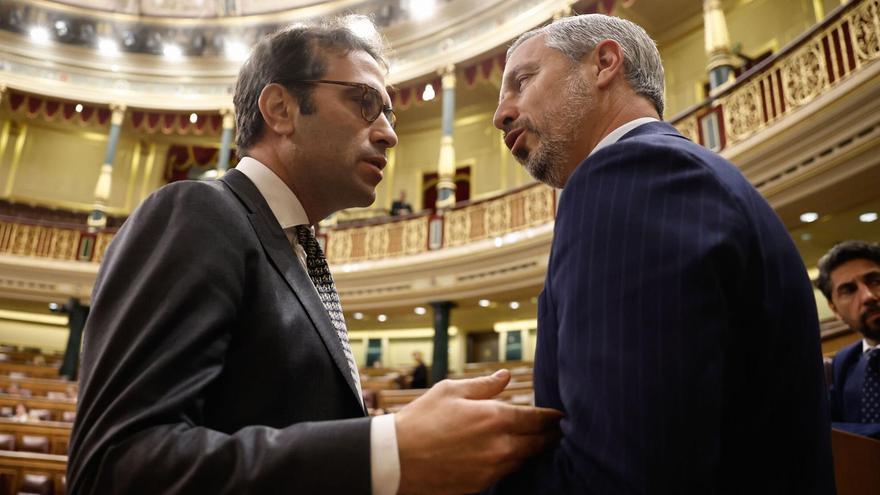 El ministro de Economía, Comercio y Empresa, Carlos Cuerpo (i), conversa con el diputado del PP, Juan Bravo (d) durante el pleno del Congreso de los Diputados.