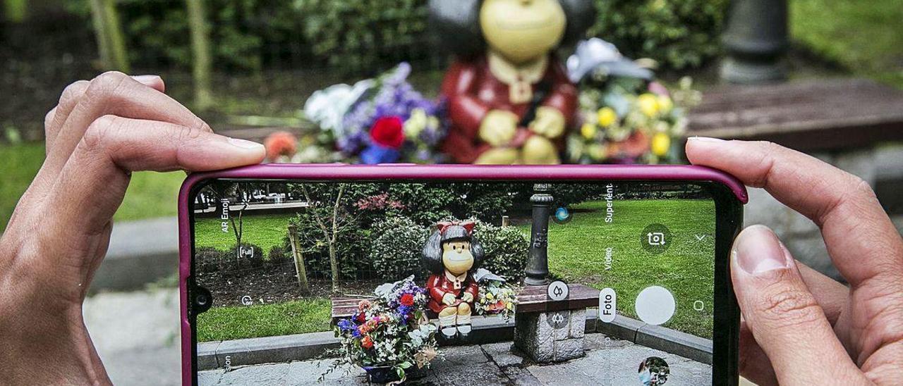 La estatua de Mafalda, ayer, en Oviedo, donde algunos ciudadanos depositaron varios ramos de flores en recuerdo de Quino.