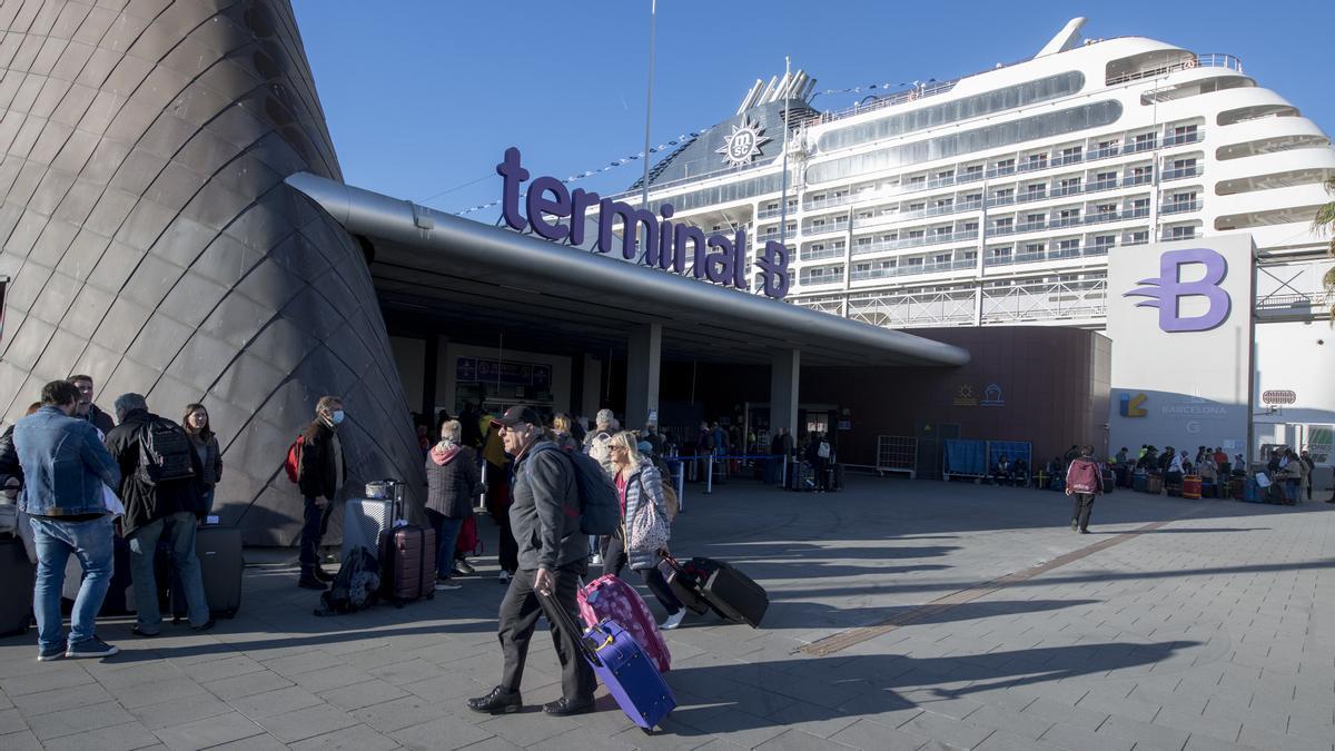 Pasajeros se dirigen a la cola de check in en la terminal B del muelle adosado para embarcar en el crucero MSC Poesía