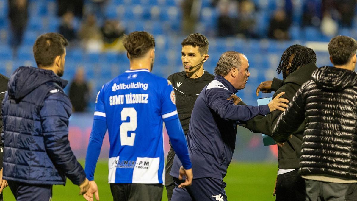 Pablo Morales, árbitro del partido, y el delegado del Hércules llevándose a Richie Dapaah.
