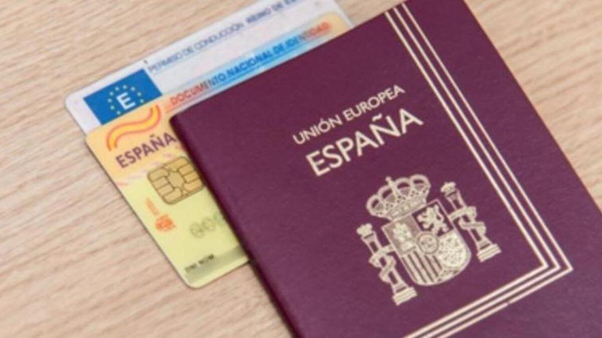 Imagen de archivo de un pasaporte junto a un DNI y un carnet de conducir
