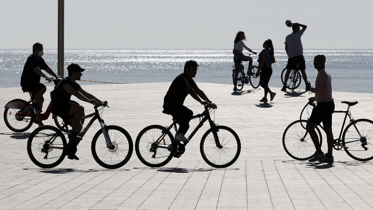 Gente con bicicletas en la playa de la Barceloneta