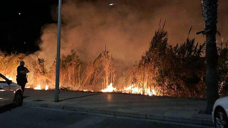 Fuego junto a vehículos aparcados