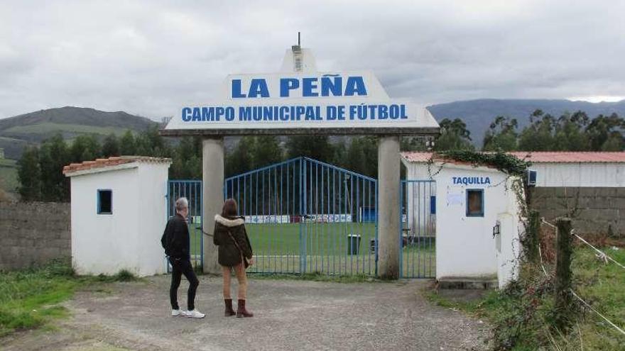 Dos personas paseando junto al campo de La Peña, ayer