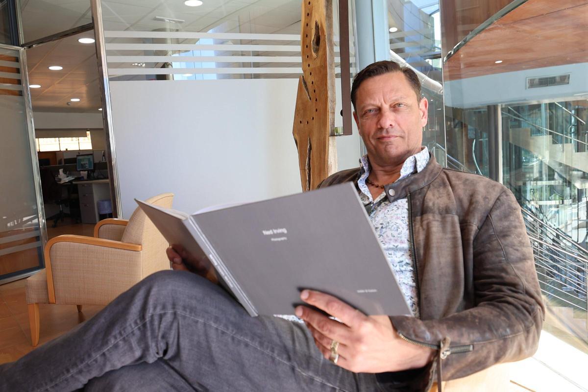 Ned Irving, el pasado miércoles, en las instalaciones de Diario de Ibiza con un catálogo de su obra fotográfica.