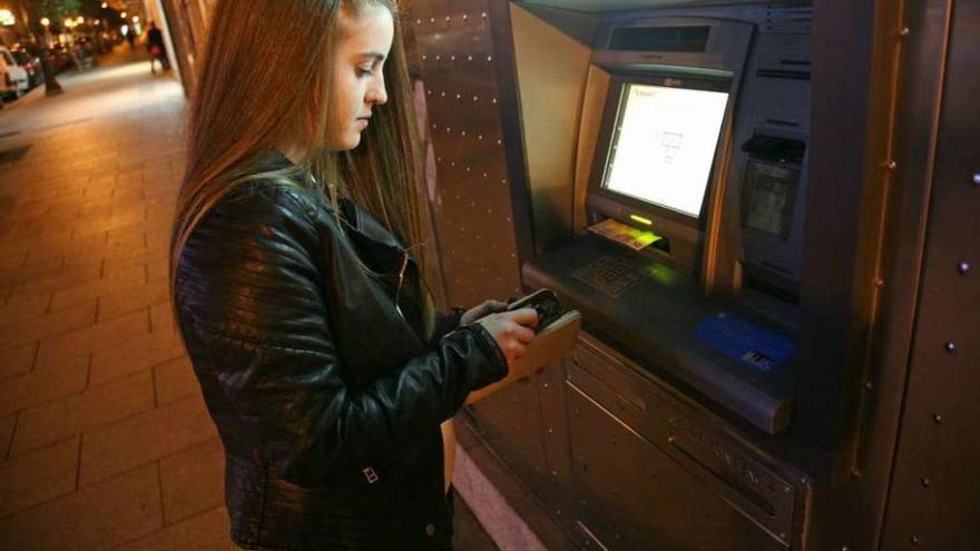 Una joven de Lalín retira, ayer, dinero de un cajero automático. // Bernabé/Luismy