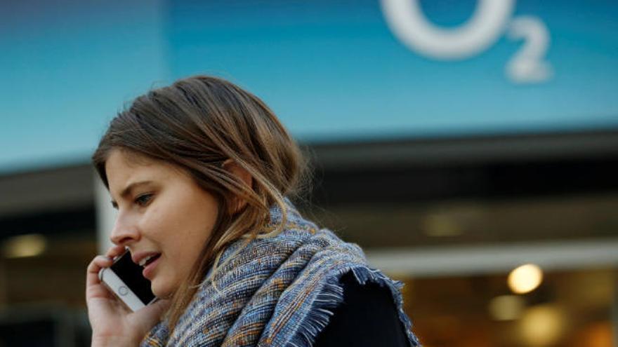 Imagen de archivo de una joven hablando por teléfono delante de una tienda de O2 en el centro de Londres.