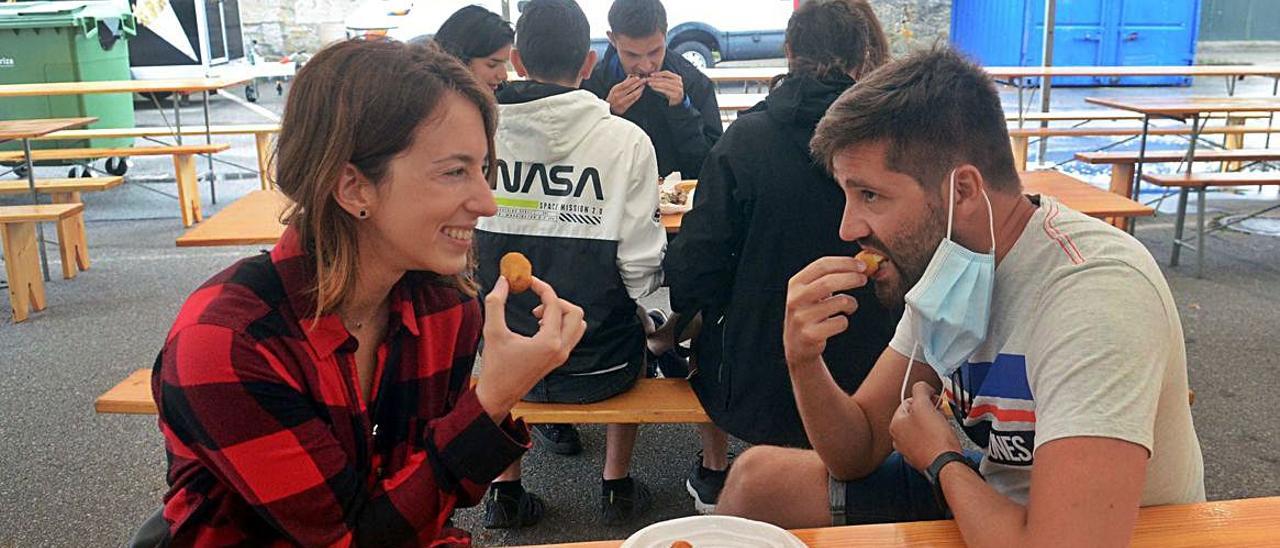 Unos comensales disfrutan de los platos preparados en la fiesta. |  // NOÉ PARGA