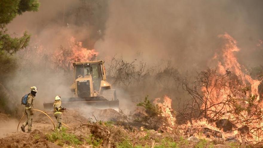 Una excavadora abre un cortafuegos en el incendioen A Canicouva en agosto pasado. |   // RAFA VÁZQUEZ