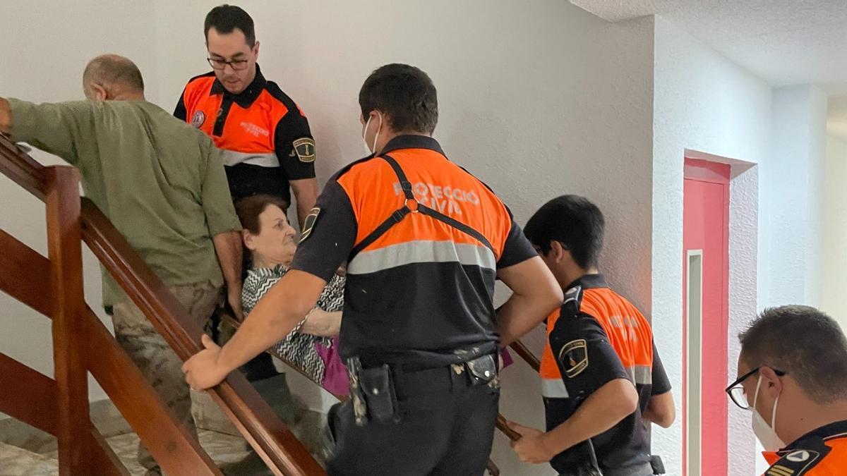 Els voluntaris ajuden a una dona a accedir a sa casa