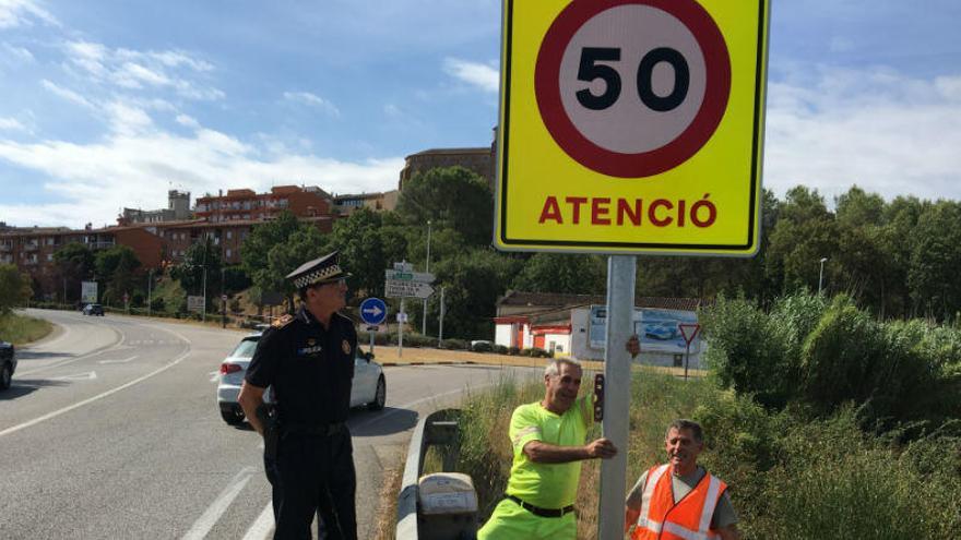Operaris de la Generalitat posant el senyal i el sergent de la Policia.