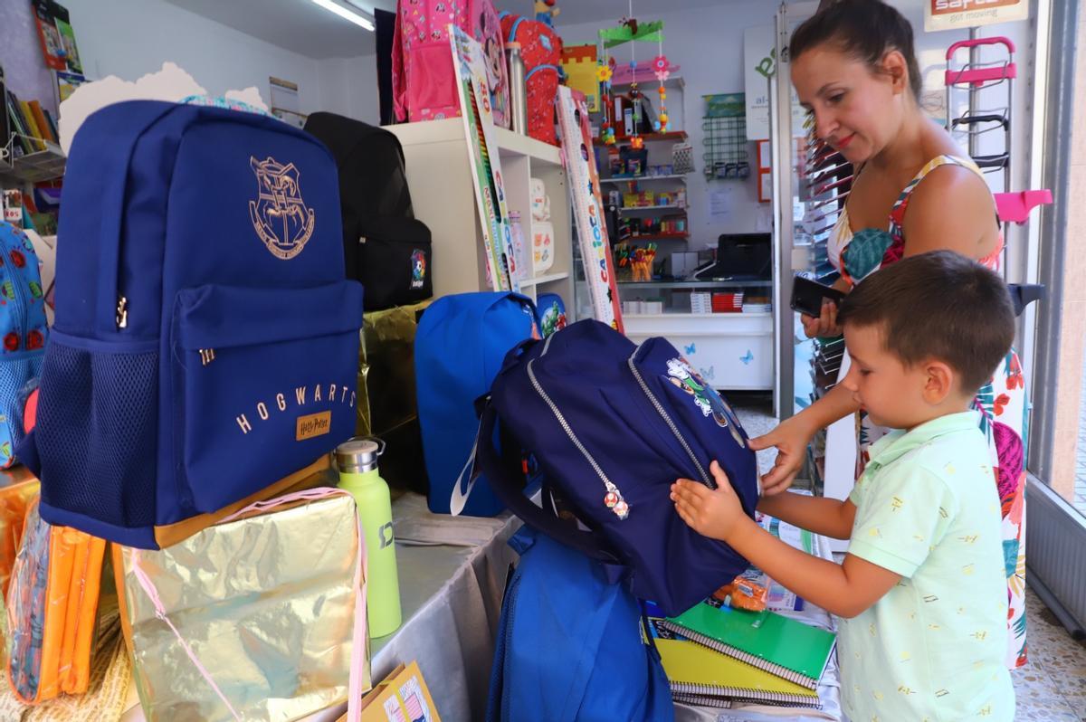 Una madre y su hijo ojean material escolar en la librería Al Andalus.