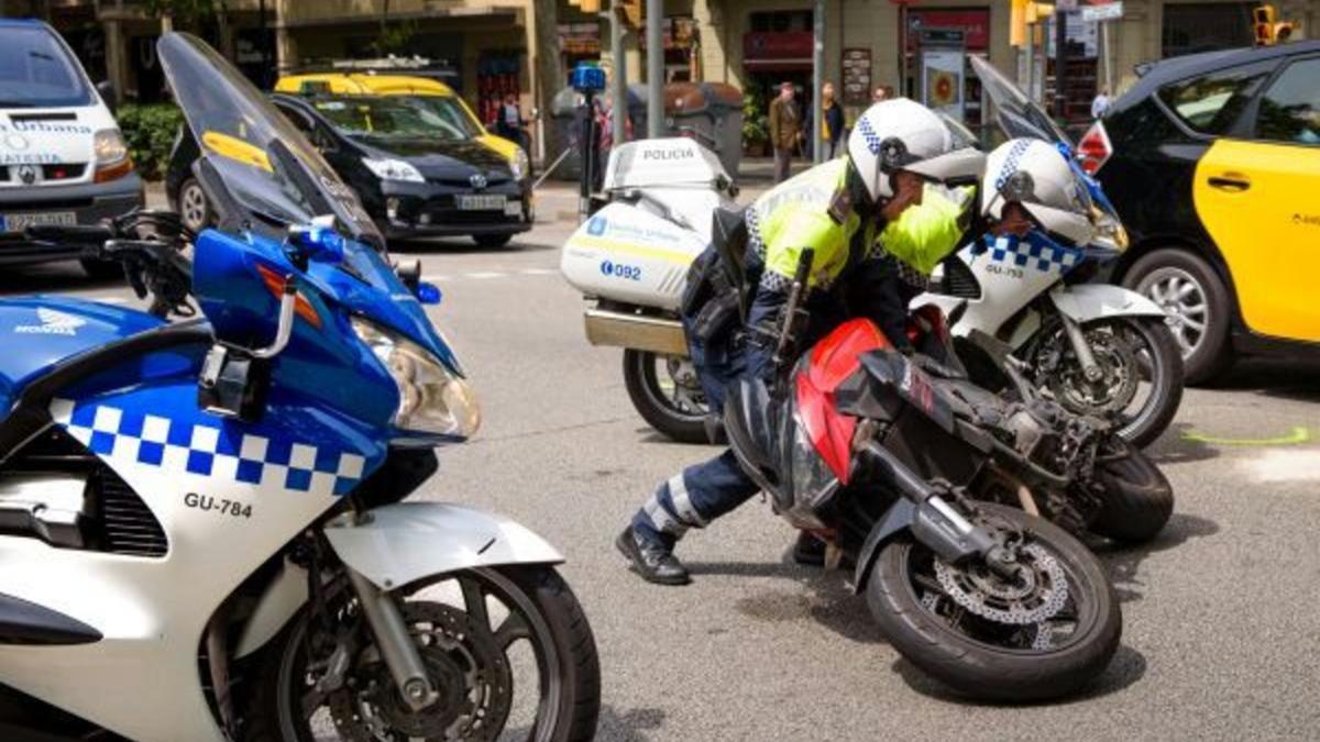 La Guardia Urbana levanta una moto tras un accidente.