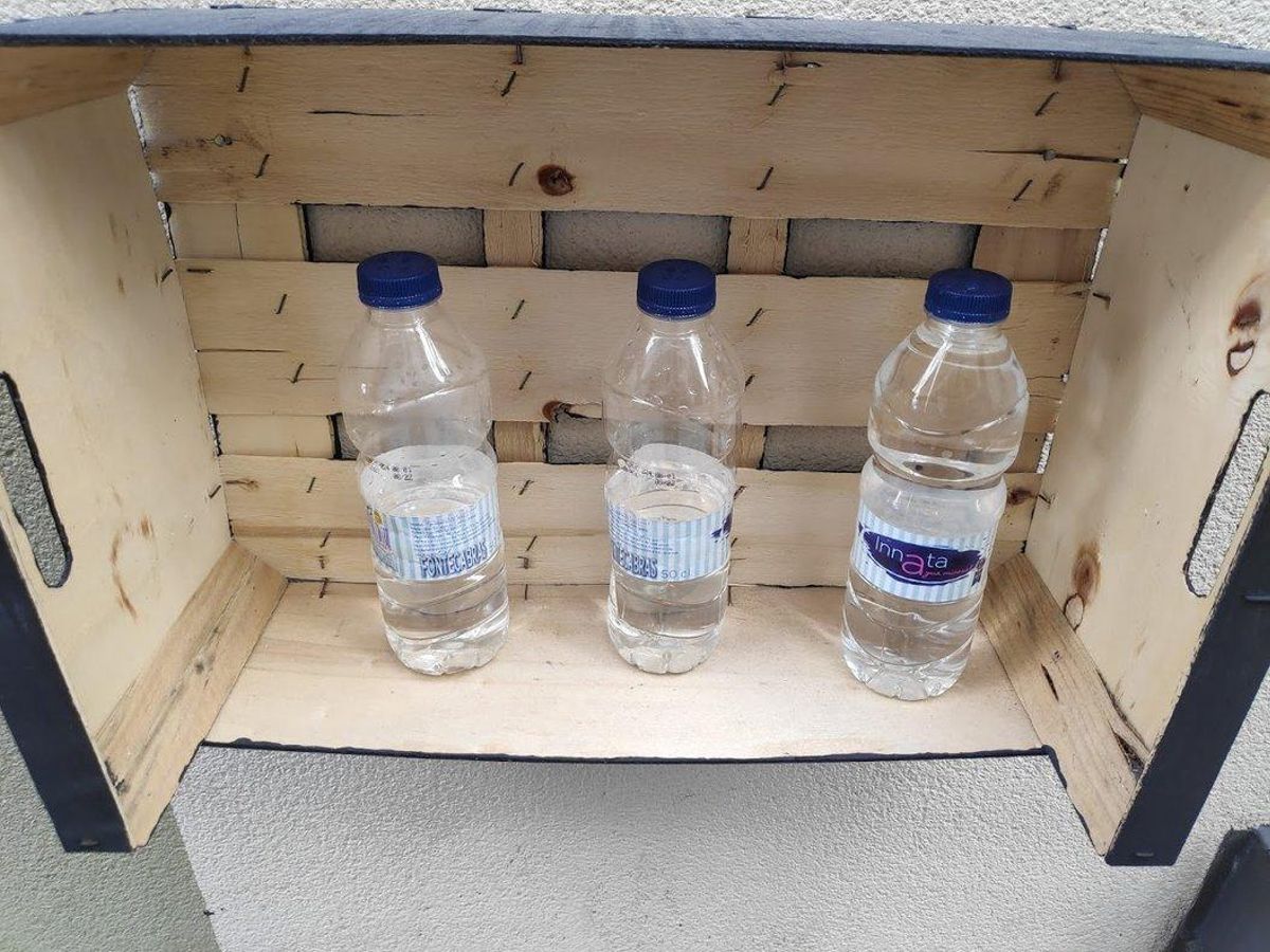 Botellas con la tapa agujereada para limpiar el suelo y las paredes de los orines de los perros en el barrio de Gràcia de Barcelona. Foto del lector Pere Guiu.