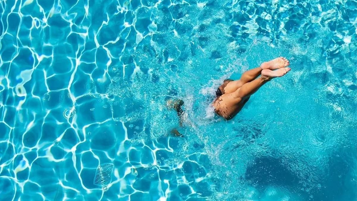 Un bañista se tira a la piscina.