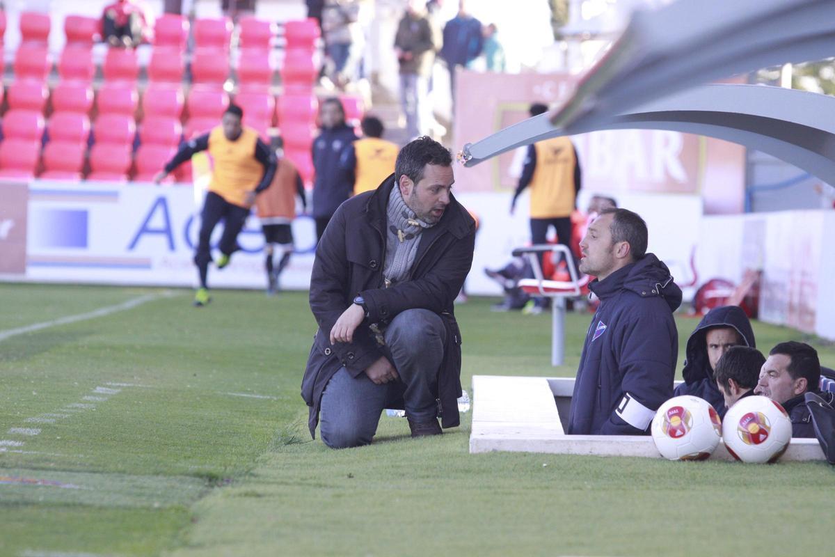 David Navarro habla con Luis Helguera, entonces delegado del equipo, en un partido del Huesca en la 13-14.