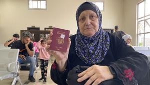 Se disponen a entrar a Egipto los primeros hispano-palestinos evacuados de Gaza. En la imagen, una mujer muestra su pasaporte español.