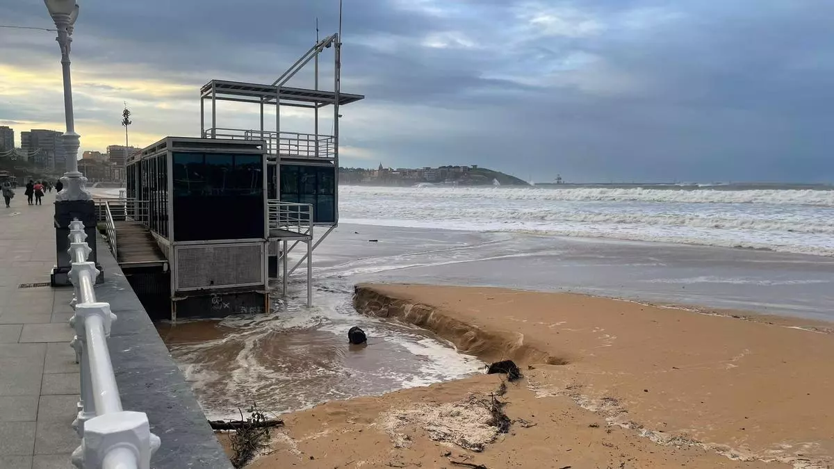 Las mareas y la lluvia en Gijón llenan de restos de ramas y troncos la playa de San Lorenzo