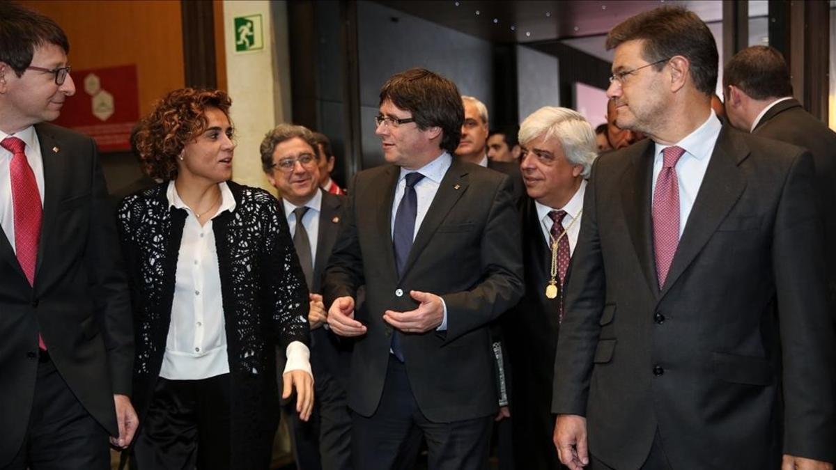 Carles Puigdemont charla con la ministra de Sanidad, Dolors Montserrat, acompañados de Rafael Catalá, en Barcelona.