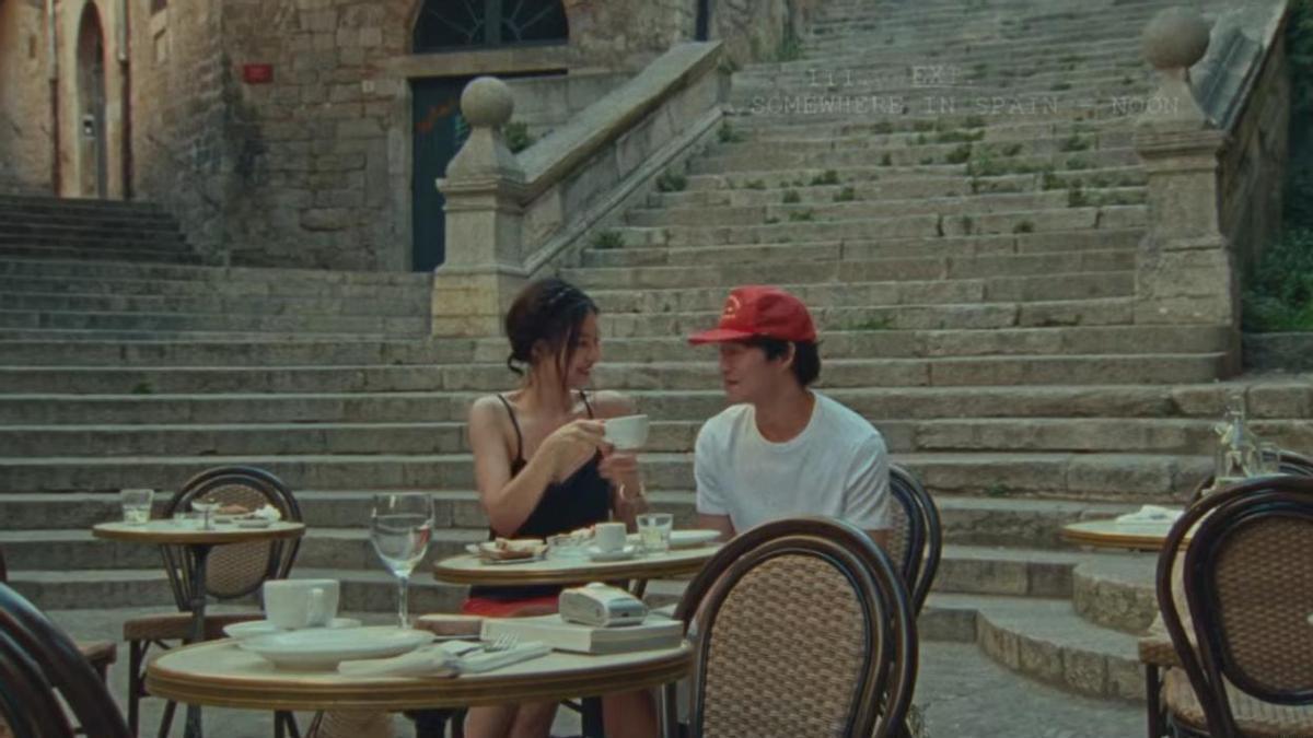 Captura del videoclip on es veu als protagonistes a la pujada de Sant Domènec sentats en una taula del restaurant cafè le Bistrot.