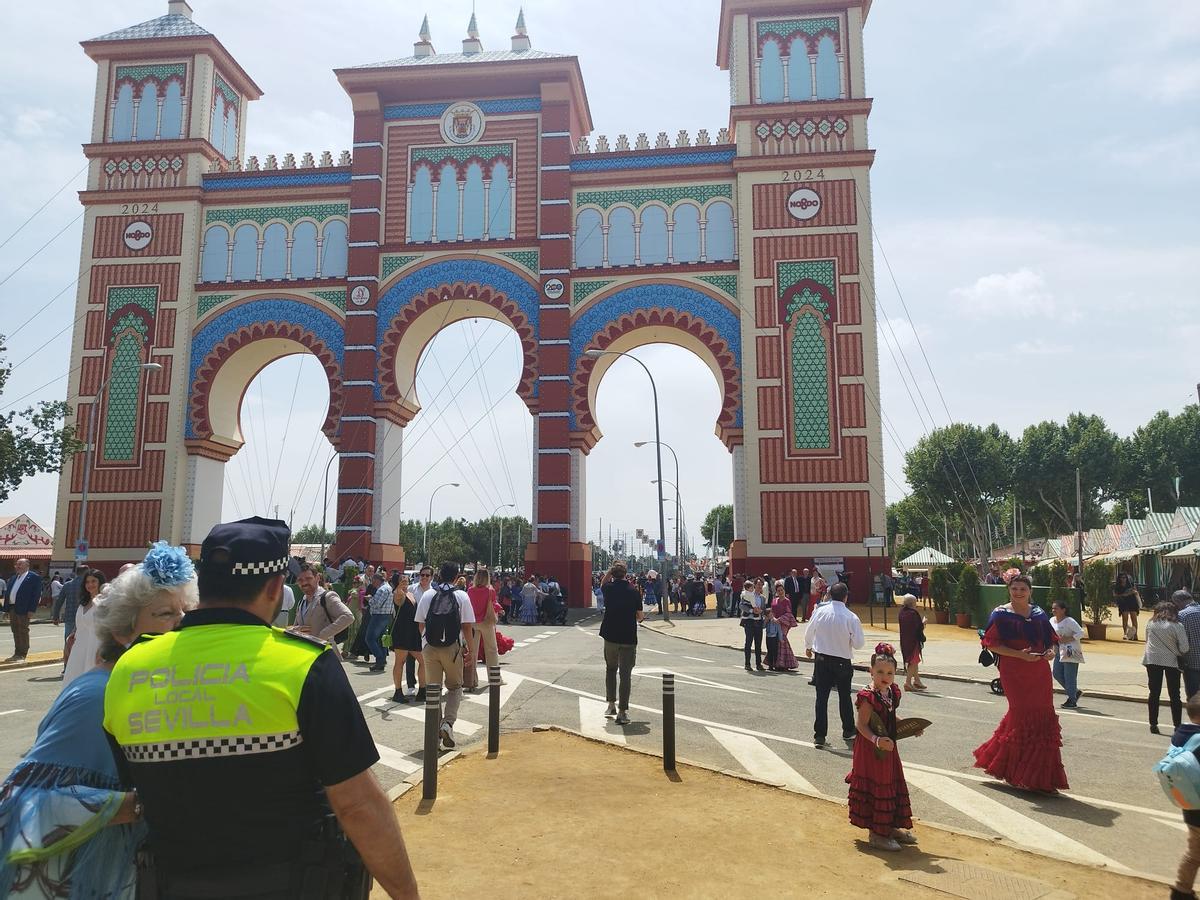 Un agente de Policía Local atiende a una visitante en la Feria de Sevilla