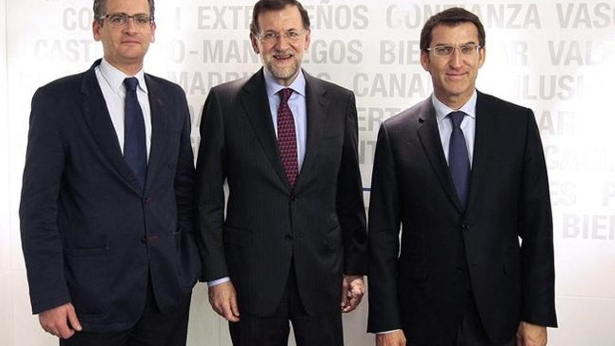 El presidente del Gobierno, Mariano Rajoy, entre el presidente del PP vasco, Antonio Basagoiti (izquierda), y el presidente electo de la Xunta de Galicia, Alberto Núnez Feijóo, este lunes, en Madrid. EFE