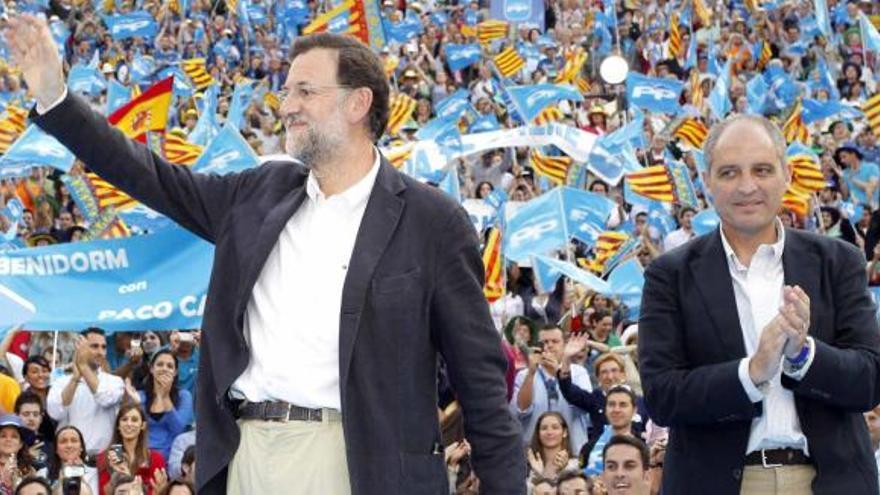 Mariano Rajoy saluda a los congregados ayer en la plaza de toros de Valencia mientras recibe el aplauso de Francisco Camps.