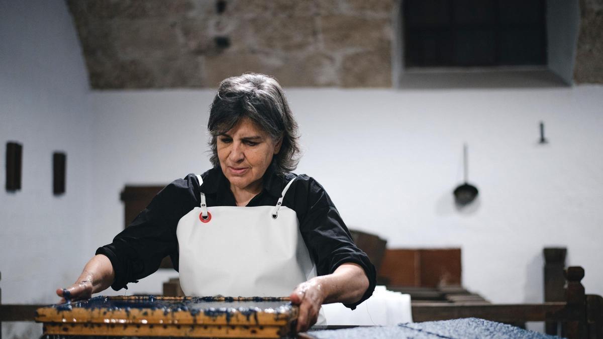 Una artesana elabora paper de manera tradicional en un dels oficis presents al programa