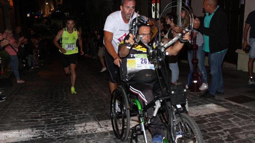 Miguel Ángel Castro, ayudando a subir una rampa a Fernando Cruz.