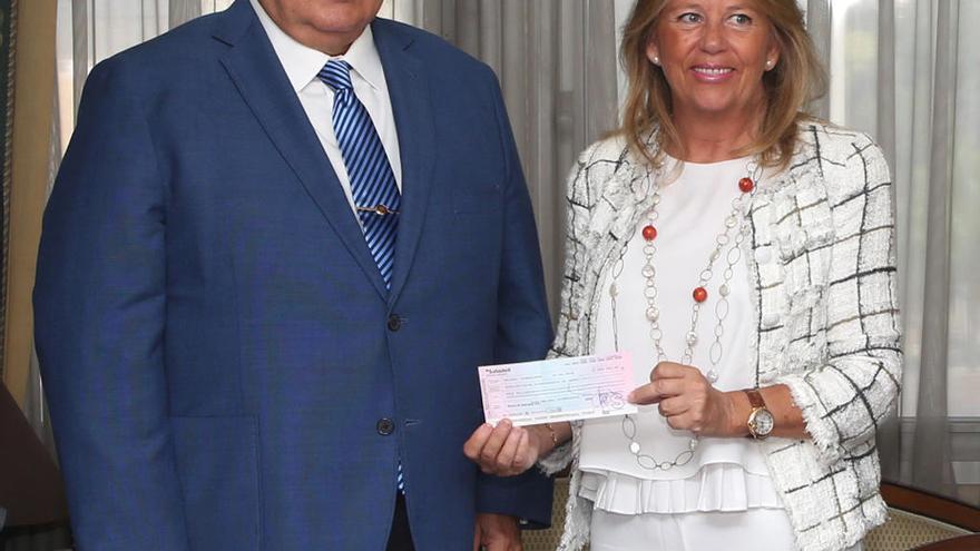 El juez José Godino entrega a Muñoz el cheque con el importe de los primeros fondos recuperados.