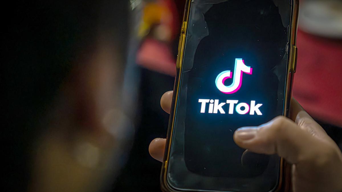 Un joven mira TikTok desde su teléfono móvil Un joven mira TikTok desde su teléfono móvil