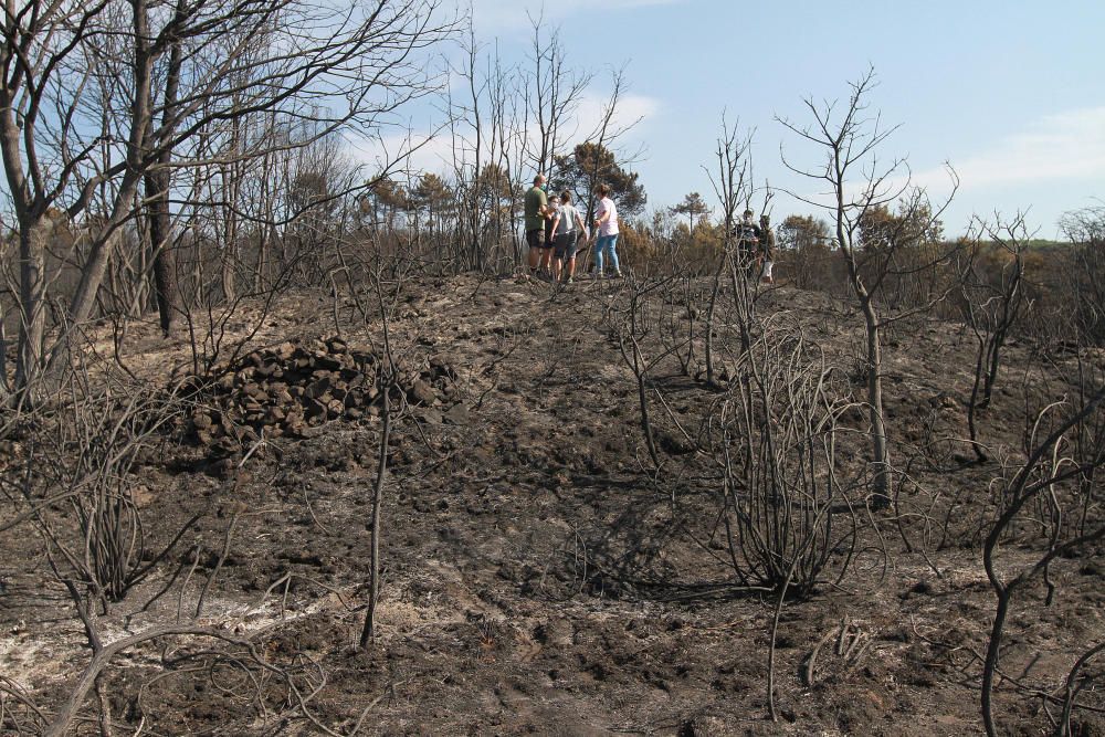 Vecinos, ayer, en torno al dolmen de 'Medoña', en Moreiras, que el fuego ha hecho más visible.